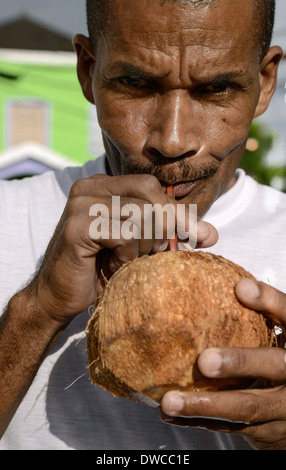 Il giamaicano uomo gode di una acqua di cocco jelly, Negril, Giamaica Foto Stock