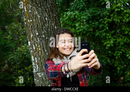 Ragazza adolescente self-fotografare in foresta Foto Stock