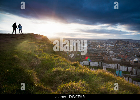 Una coppia giovane tenere le mani davanti la vista della città di Edimburgo da Salisbury Crags Foto Stock