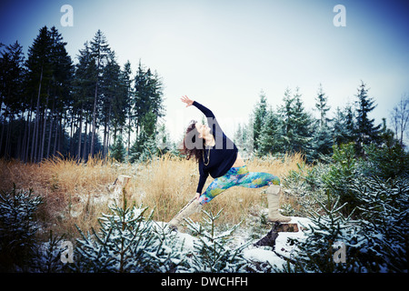 Metà donna adulta la pratica dello yoga nella foresta Foto Stock