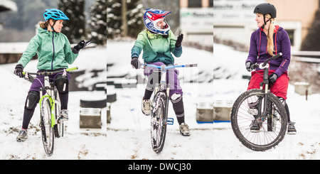 Tre femminili mountain bikers in bici e in chat Foto Stock