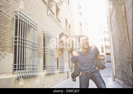 Turista giovane dando piggy back ride, Valencia, Spagna Foto Stock