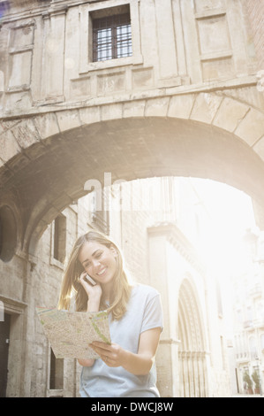 Giovane donna che guarda la mappa al di fuori del Cattedrale di Valencia, Valencia, Spagna Foto Stock