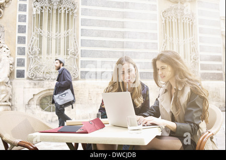 Due giovani donne guardando il laptop al di fuori del Museo della Ceramica, Valencia, Spagna Foto Stock