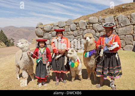 Alle donne indigene e la ragazza con alpaca, fortezza Inca Sacsayhuaman, Cuzco, Perù, Sud America Foto Stock