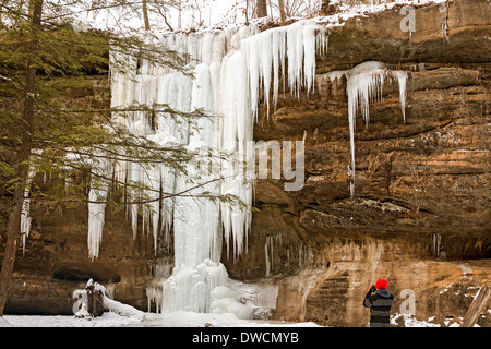 Visitatore fotografie congelate le Cascate Inferiori in inverno a Old Man's Cave, Hocking Hills State Park, Ohio. Foto Stock