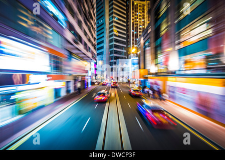 Hong Kong e la Cina la sfocatura in movimento attraverso la città da un tram. Foto Stock