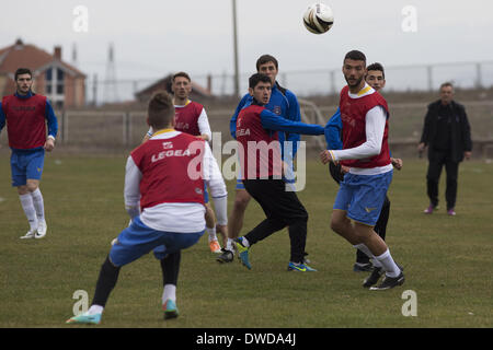 A Pristina, in Kosovo. 4 Mar 2014. Membri del Kosovo Team Nazionale pratica presso la KeK stadium sul Kastriot Obilic/distretto di Pristina, vicino alla centrale elettrica del Kosovo, descritta come la peggiore a singolo punto fonte di inquinamento in Europa. Il gioco sarà il loro primo FIFA sanzionato corrisponde una partita amichevole contro Haiti, mercoledì 5 marzo. Foto di JODI HILTON/NURPHOTO © Jodi Hilton/NurPhoto/ZUMAPRESS.com/Alamy Live News Foto Stock