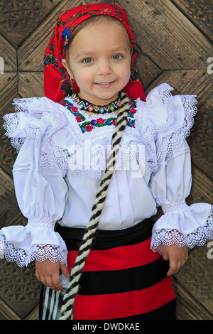 Bambina rumena che indossano abiti tradizionali e tradizionali in legno sullo sfondo della porta Foto Stock