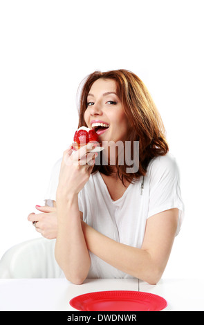 Bella donna fresco di mangiare la torta di fragole isolato su uno sfondo bianco Foto Stock