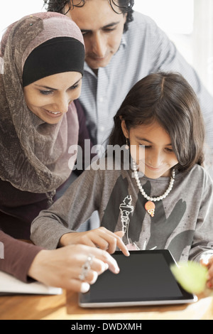 Famiglia di tre persone con tavoletta digitale insieme a casa Foto Stock