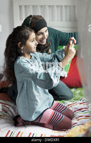 Madre e figlia di fotografare in camera da letto Foto Stock