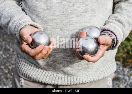 Sezione mediana di senior uomo con le palle di bocce all'aperto Foto Stock