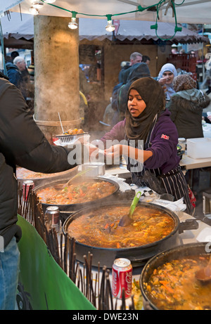 Giovane donna che serve cibo caldo di strada marocchino presso lo stand del mercato York North Yorkshire Inghilterra Regno Unito Gran Bretagna Foto Stock