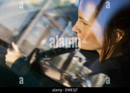 Vista di imprenditrice car guida attraverso la finestra Foto Stock