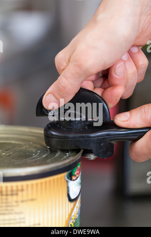 Uomo di aprire una lattina di cibo in scatola Foto Stock