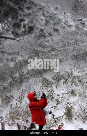 Huangshan, cinese della provincia di Anhui. 6 Mar 2014. Un turista prende le foto della neve scenario in montagna Huangshan, est cinese della provincia di Anhui, 6 marzo 2014. Credito: Shi Guangde/Xinhua/Alamy Live News Foto Stock