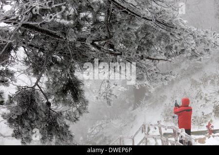 Huangshan, cinese della provincia di Anhui. 6 Mar 2014. Un turista prende le foto della neve scenario in montagna Huangshan, est cinese della provincia di Anhui, 6 marzo 2014. Credito: Shi Guangde/Xinhua/Alamy Live News Foto Stock