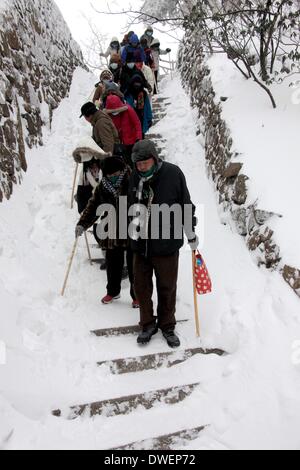 Huangshan, cinese della provincia di Anhui. 6 Mar 2014. I turisti a piedi giù per la coperta di neve passi in montagna Huangshan, est cinese della provincia di Anhui, 6 marzo 2014. Credito: Shi Guangde/Xinhua/Alamy Live News Foto Stock