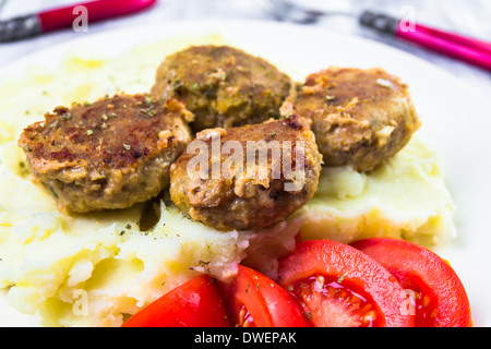 Fritte costolette di maiale con patate lesse e pomodori Foto Stock