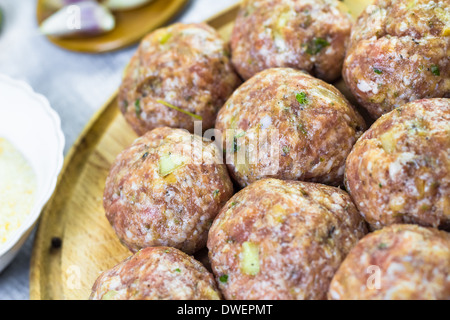 La carne cruda di palline di carne macinata preparata per passatele nel pangrattato Foto Stock