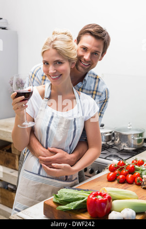 Amare giovane coppia con bicchiere di vino in cucina Foto Stock