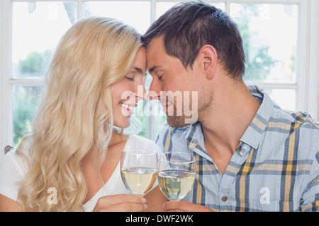 Amare giovane con gli occhi chiusi tenendo bicchieri di vino Foto Stock