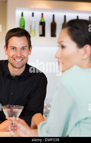 Barman sorridenti con una donna al bancone bar Foto Stock