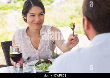Coppia felice la tostatura con vino rosso su una data Foto Stock
