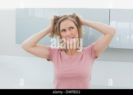 Orinato donna tirando i capelli Foto Stock