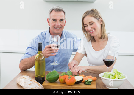 Amare giovane con bicchieri di vino in cucina Foto Stock