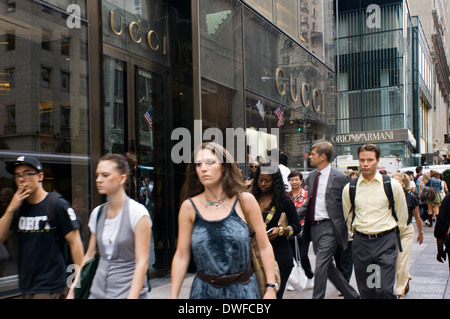 Persone che passeggiano lungo la Quinta Avenue a vetrina negozio di Gucci. I negozi di lusso associata alla Quinta Avenue cominciarono ad apparire quando Foto Stock