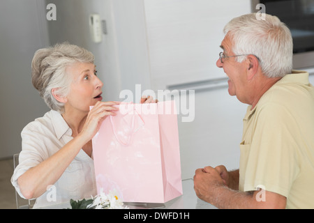 Felice donna senior ottenendo un regalo dal suo partner Foto Stock