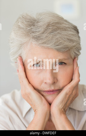 Premuto senior donna che guarda la fotocamera Foto Stock