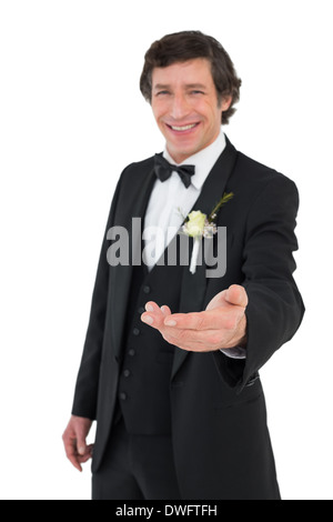 Sorridente groom offrendo la mano Foto Stock