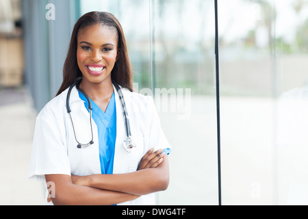 Bella African American infermiera con le braccia incrociate Foto Stock