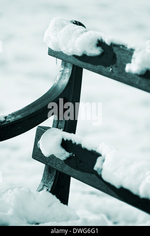 Close-up di un parco in legno panchina coperta di neve Foto Stock