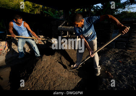Penonome, Cocle Affitto provincia, Repubblica di Panama. Il 7 marzo 2014. Guillermo Jaen, 51, (sinistra) e Marco Antonio, 42, miscele di cemento, acqua e sabbia per i blocchi di calcestruzzo al materiale di costruzione impianto Industrias Gordon S.A in Penonome, Cocle Affitto provincia, Repubblica di Panama, venerdì 7 marzo 2014. Foto Stock