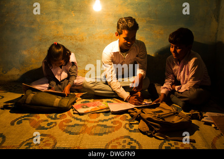 Rurale indiano di lettura dello studente nella notte a casa Foto Stock