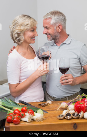 Amorevole Coppia matura con bicchieri di vino in cucina Foto Stock