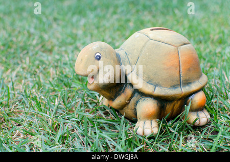 Tartaruga felice salvadanaio in erba verde Foto Stock