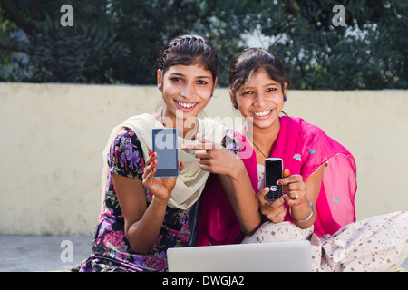 Rurale indiano ragazze che mostra il telefono cellulare Foto Stock