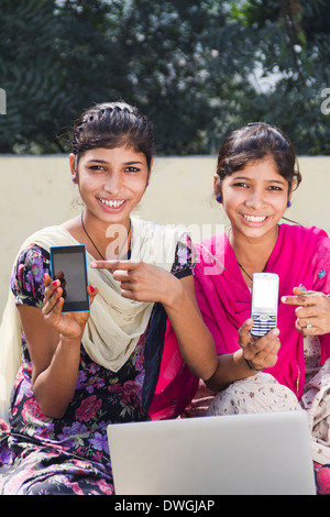 Rurale indiano ragazze che mostra il telefono cellulare Foto Stock