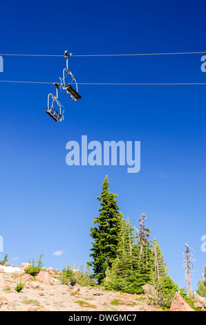 Impianti di risalita con un profondo cielo blu che passa oltre il verde di pini d'estate sul Monte Cofano Foto Stock