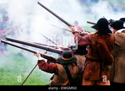 Guerra Civile Inglese, moschetto fire in battaglia, secolo XVII, la rievocazione storica della Battaglia di Naseby soldato soldati sparando moschetti gun smoke uniforme militare uniformi England Regno Unito Foto Stock