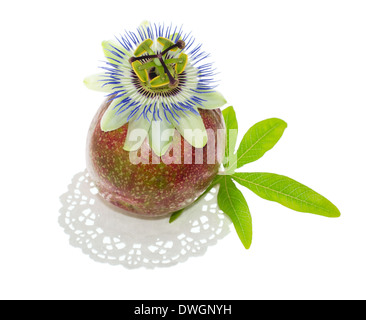 Passiflora su un frutto della passione con una foglia, su un tovagliolo è isolato su sfondo bianco, primo piano Foto Stock