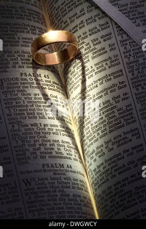 Un anello di nozze su una Bibbia aperta una colata a forma di cuore ombra. Foto Stock