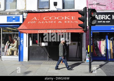 Un uomo cammina passato Cooke pie e mash shop nel pastore, Londra Foto Stock