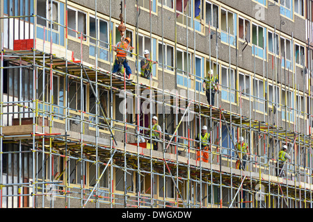 Scaffolders lavorando su uno dei vuoti Heygate Estate alta crescita sociale di blocchi di alloggiamento in preparazione per i lavori di demolizione Southwark Sud Londra Inghilterra REGNO UNITO Foto Stock