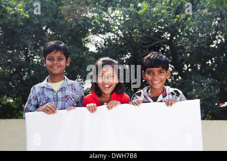 Bambini indiani in piedi con la Bacheca Foto Stock